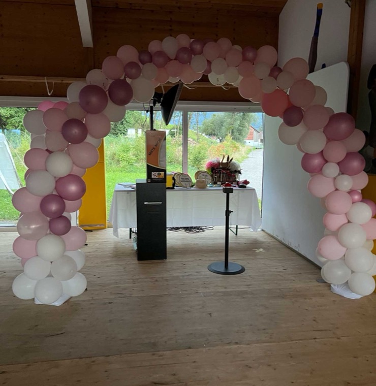Fotobox unter einem Ballonbogen in rosa und weiss